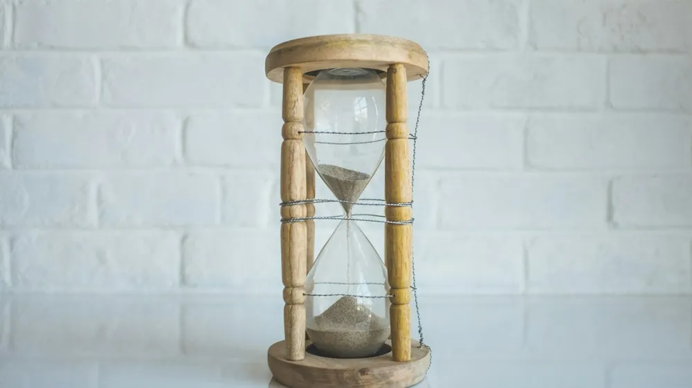 Reloj de arena sobre una mesa: pico de seguidores y alcance en Instagram