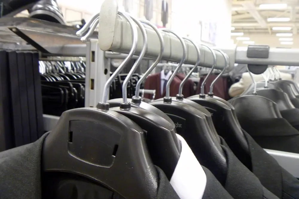 Prendas colgadas en percheros de una tienda de ropa, referencia al contenido de moda urbana en Instagram Peru