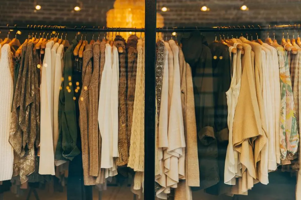 Percha de ropa colgada en una tienda boutique con luces cálidas, referencia al nicho de moda de una creadora peruana en Instagram