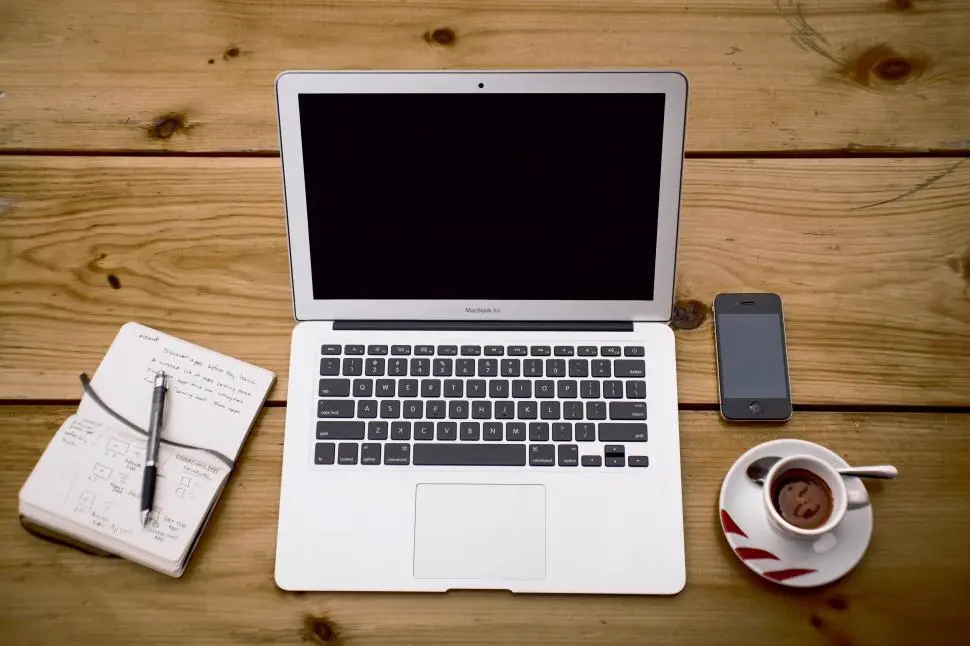 Laptop, telefono y taza de cafe sobre un escritorio, referencia al contenido de lifestyle en Instagram Peru