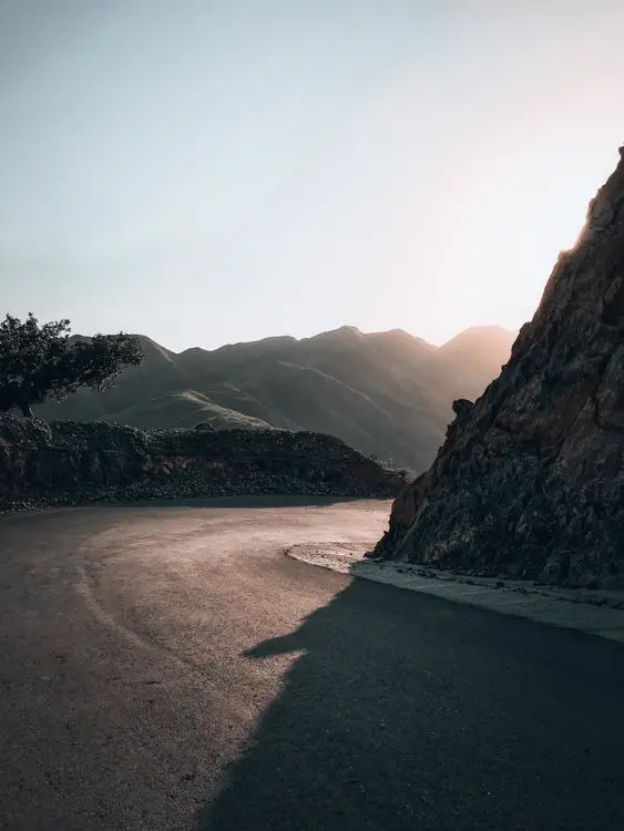 Curva de un camino de montaña al atardecer, imagen referencial del contenido de viajes y lifestyle en Instagram Perú