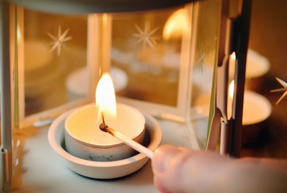 Vela aromática encendida con un fósforo dentro de un portavelas, referencia al emprendimiento de velas de una creadora de Instagram en Perú